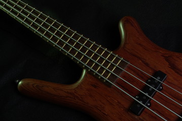 Fototapeta na wymiar Bass guitar with brown body on black