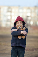 portrait of a homeless boy with bear
