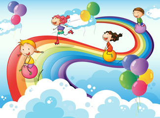 Obraz na płótnie Canvas A group of kids playing at the sky with a rainbow