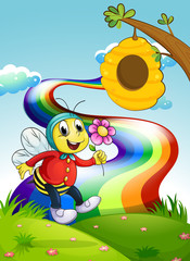 Obraz na płótnie Canvas A smiling bee holding a flower at the hilltop with a rainbow