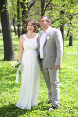 Beautiful newly married couple walking in the park