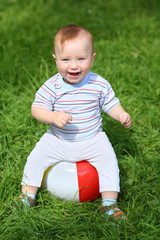 Smiling little boy sitting on an inflatable ball