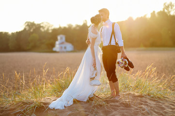 Fototapeta na wymiar Bride and groom on a beach at sunset