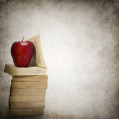 Grunge background with stack of books and red apple