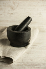 Black granite Mortar and Pestle on wooden background. Close-up.