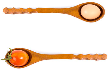 egg and tomato on a wooden spoon.