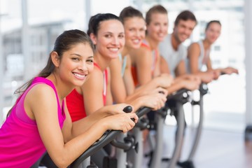 Fit young people working out at spinning class