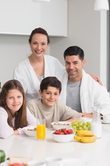 Happy kids enjoying breakfast with parents