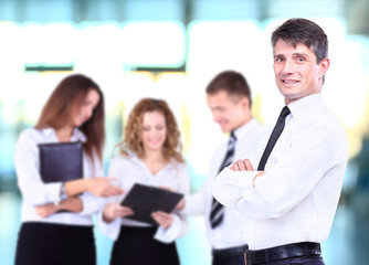 Successful business man standing with his staff