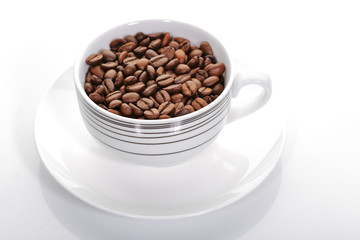 A cup full of coffee beans on a white background