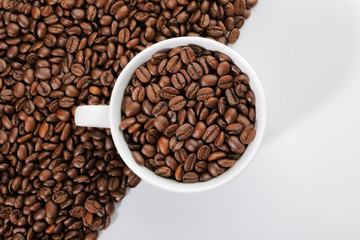 A cup of coffee beans on the edge of diagonal coffee beans shape