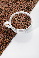 A cup of coffee beans on the edge of diagonal coffee beans shape