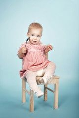 cute little girl with spoon sitting on chair