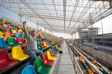 Screaming  man with hands up in the seats for spectators