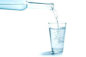 Wasser aus der Flasche ins Glas, weisser Hintergrund
