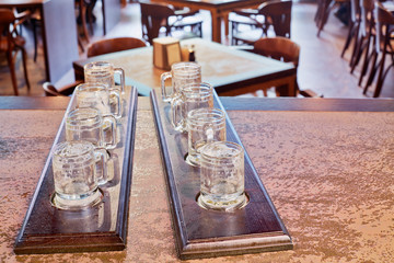 Two beer paddles with empty beer mugs on counter