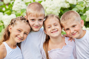 Portrait of four smiling children standing head to head