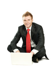 Portrait of a happy young businessman working on laptop