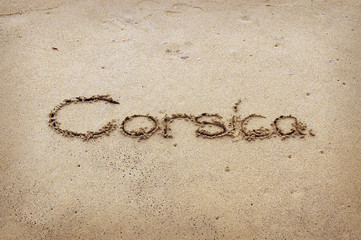 Corsica - written in sand on beach texture