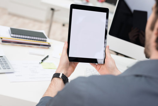 gesch&auml;ftsmann h&auml;lt tablet in der hand