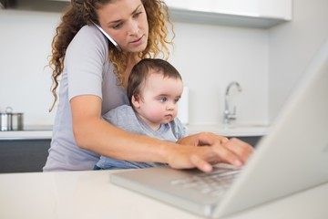 Woman multi tasking at kitchen counter