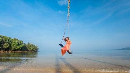 Girl on a swing at the beach