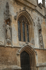 Fototapeta na wymiar Drewniane drzwi kościoła i poplamione łukowe okna, Anglia