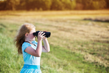 girl looking through binoculars outdoor
