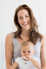 Close-up portrait of a smiling mother and baby