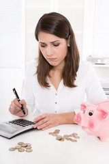 Obraz na płótnie Canvas Frau kalkuliert ihre Finanzen - sitzend im Büro