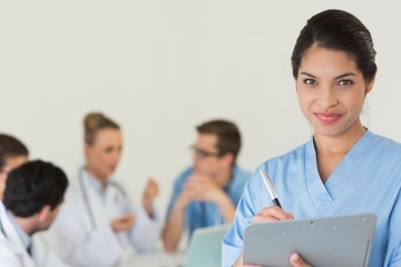 Female nurse writing on clipboard