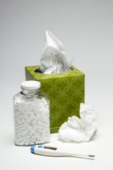 Tissue with thermometer and bottle of aspirin, vertical