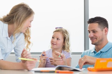Obraz premium Parents assisting girl in drawing at table