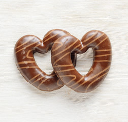 Chocolate hearts on white wooden table.