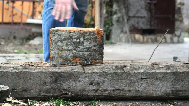 Lumber jack man chopping wood logs with ax. Making firewood