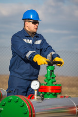 Obraz premium Oil worker turning valve