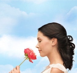 smiling woman smelling flower