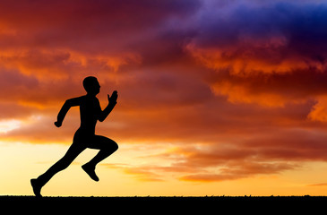 Fototapeta na wymiar Silhouette of running man on sunset fiery background