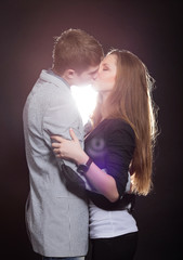 Beautiful young smiling couple in love embracing indoor
