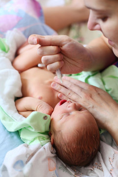 Mother Feeding Newborn Baby Milk With Syringe