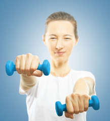 Young woman with dumbbells, focus on the dumbbell