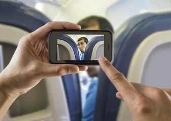 photographing a surprised man on a plane