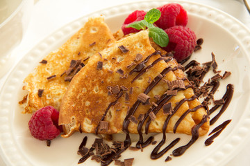 Delicious pancakes with berries and chocolate sauce.