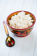 Cottage cheese, white wooden background, vertical shot