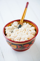 Vertical shot of cottage cheese in a wooden bowl, close-up
