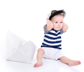 cute baby boy sitting in captain cap with ship of paper - sailor