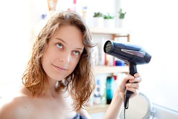 Young girl taking care of her hairs in a bathroom