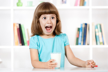Little girl with glass of milk making a face