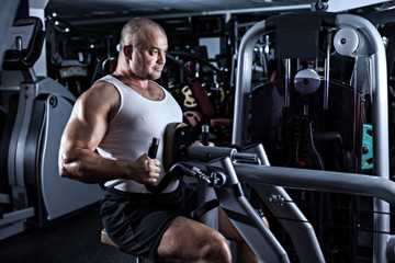 Fototapeta na wymiar Man doing workout with pull-down mashine