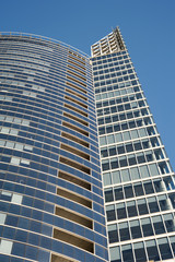 Obraz premium Modern business glass building on blue sky background